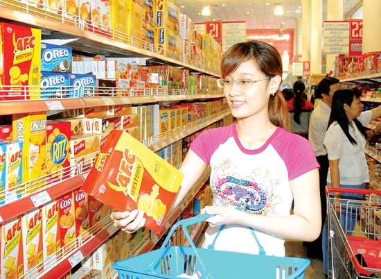 A customer chooses Vietnamese cake products at a supermarket in HCMC (Photo: SGGP)